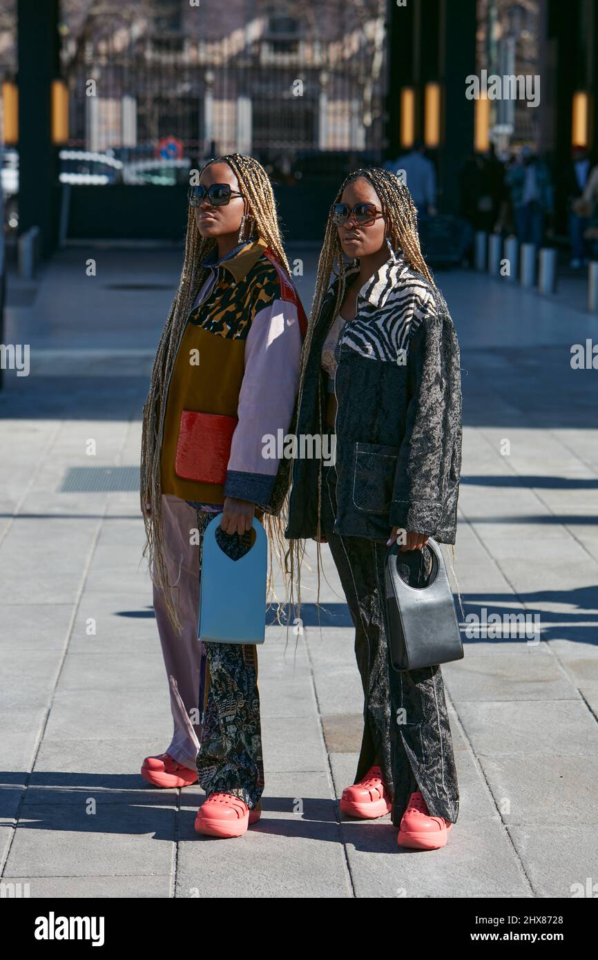MILAN, ITALY - FEBRUARY 23, 2022: Women with braids and Marco Rambaldi blue and black bags before Marco Rambaldi fashion show, Milan Fashion Week stre Stock Photo