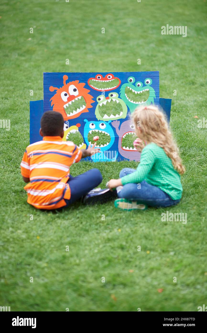 Children playing in garden with cardboard monster toss game Stock Photo Alamy