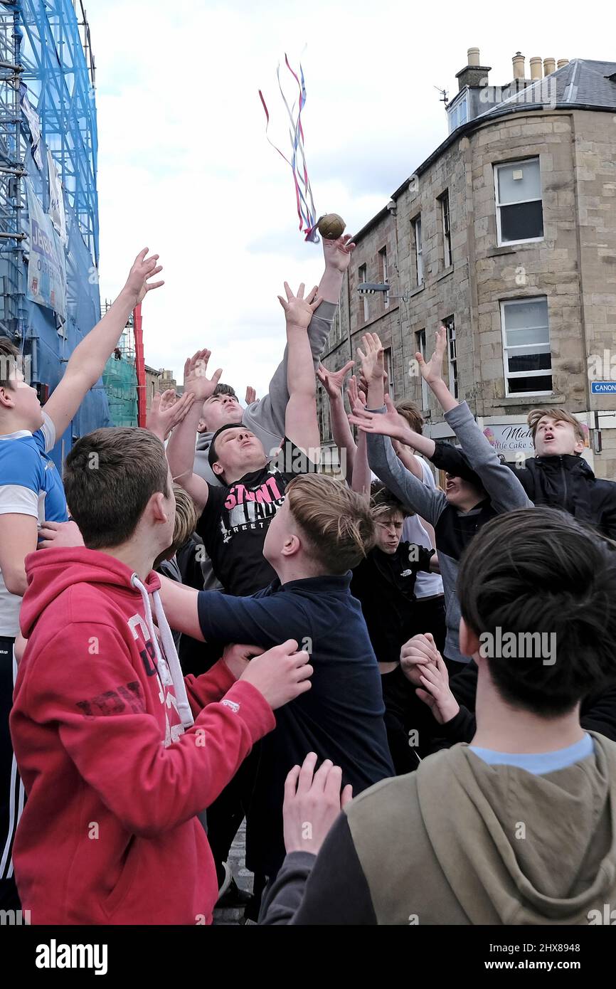Jedburgh, Thursday 10 March 2022. Youths challenge for the “hailed” “Ba” during the annual 'Fastern Eve Handba' event in Jedburgh's High Street in the Scottish Borders on March 10, 2022 in Jedburgh, Scotland. The annual event, which started in the 1700's, takes place today and involves two teams, the Uppies (residents from the higher part of Jedburgh) and the Doonies (residents from the lower part of Jedburgh) getting the ball to either the top or bottom of the town. The ball, which is made of leather, stuffed with straw and decorated with ribbons is thrown into the crowd to begin the game. ( Stock Photo