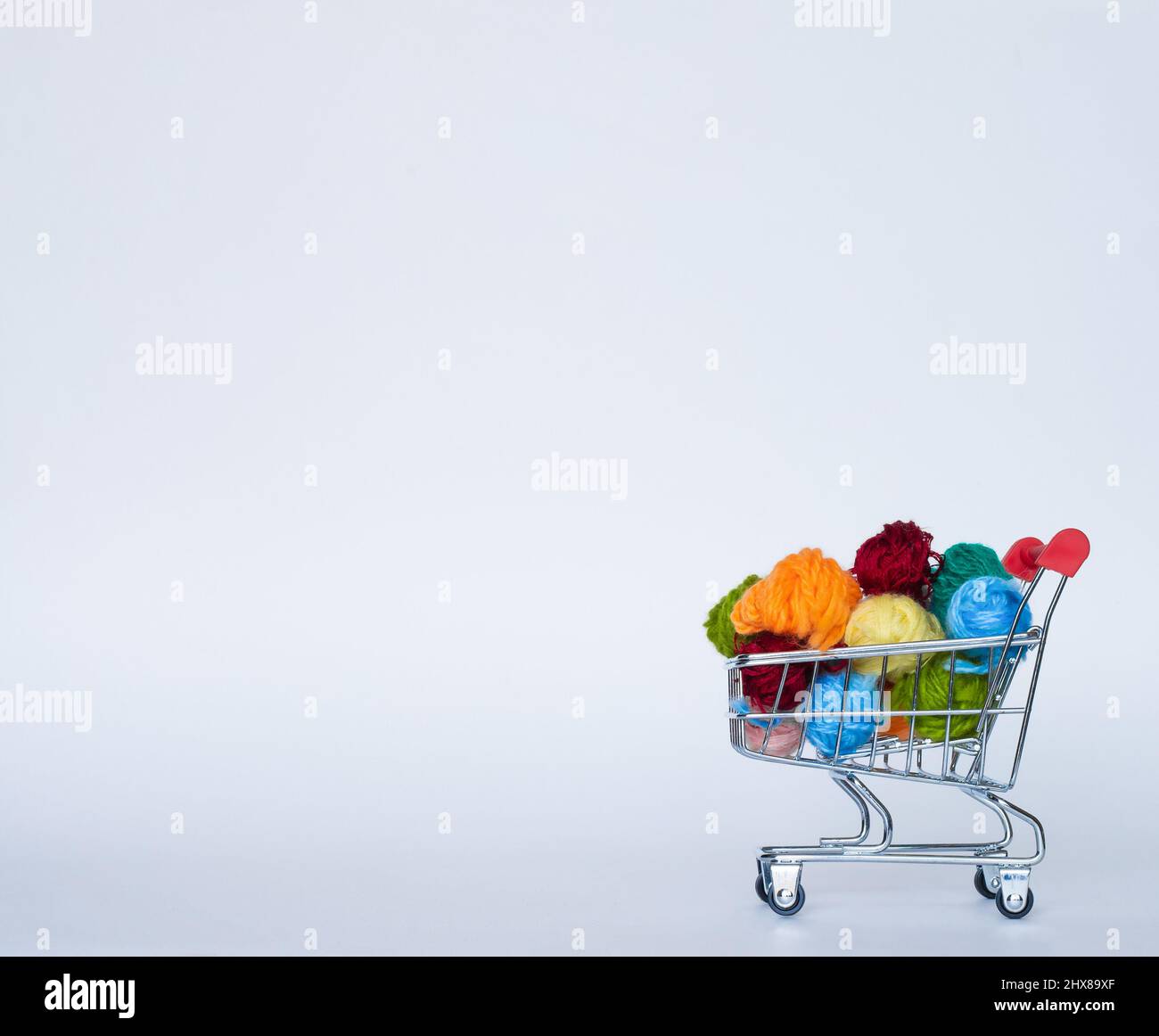 Trolley with yarn for knitting. Needlework. Hobbies and recreation. Colored threads on a white background. copy space, side view Stock Photo