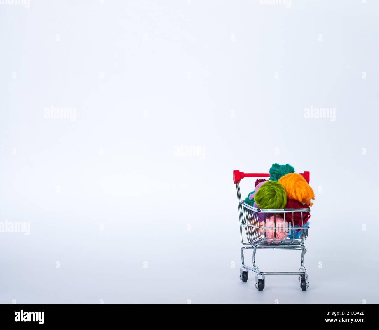 Trolley with yarn for knitting. Needlework. Hobbies and recreation. Colored threads on a white background. copy space, front view Stock Photo