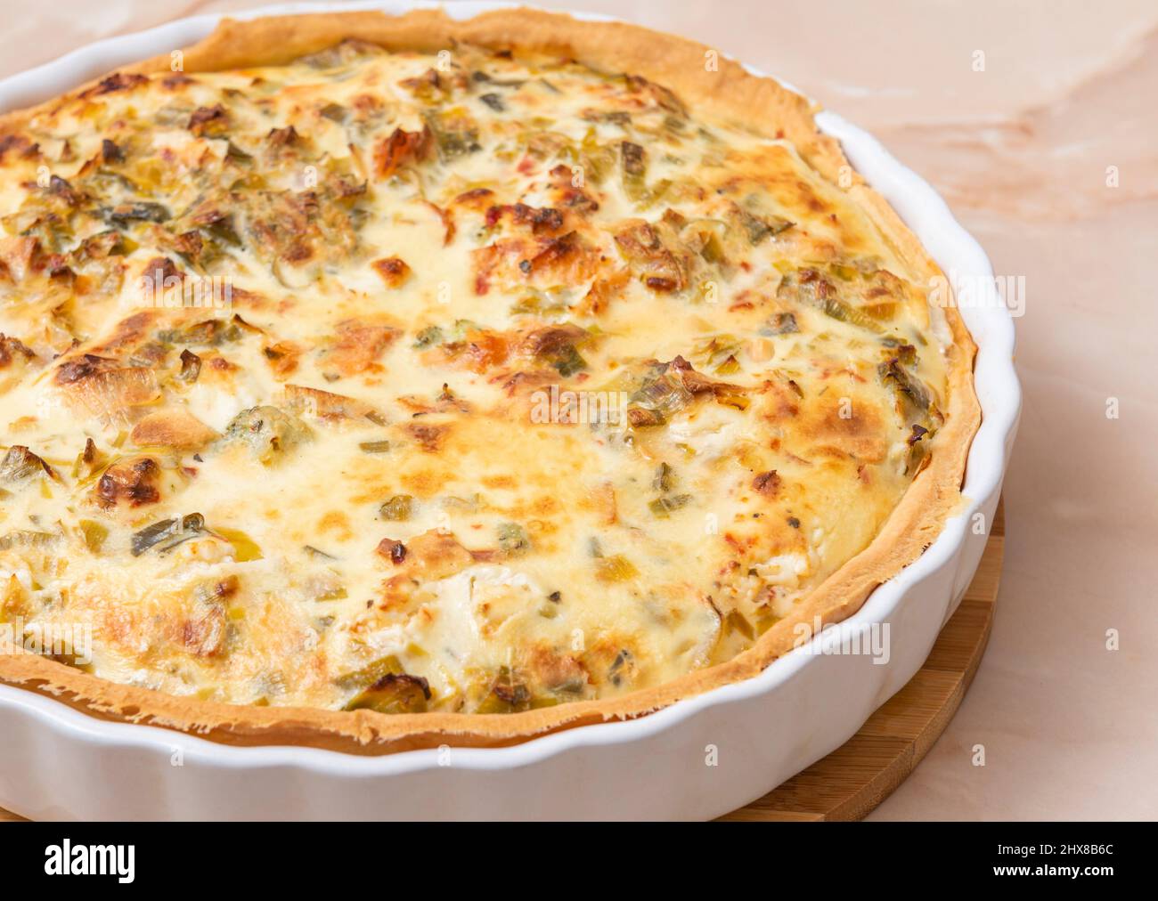 Sliced traditional French open quiche pie with feta cheese and scallion