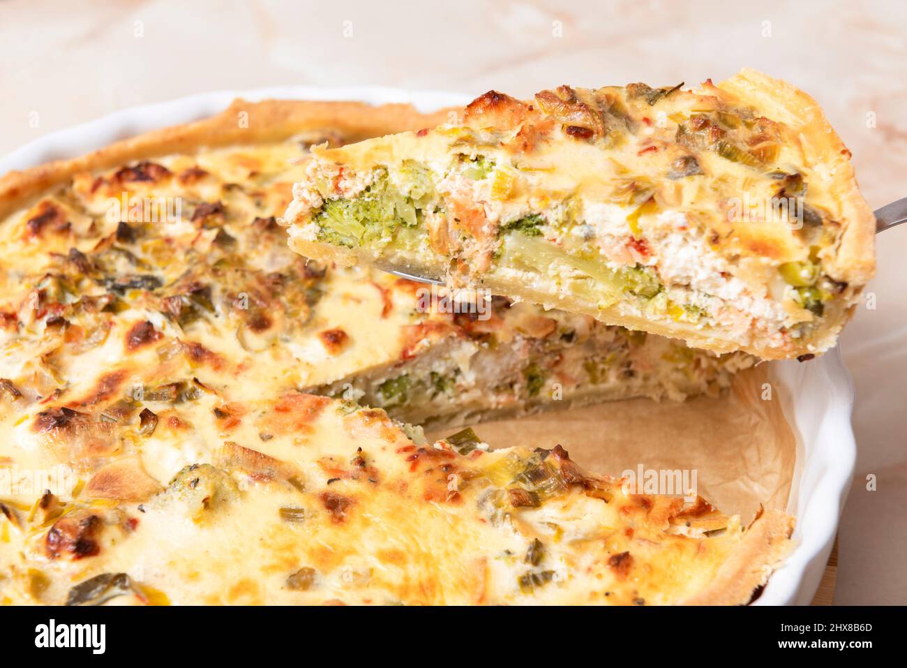 Sliced traditional French open quiche pie with feta cheese and scallion