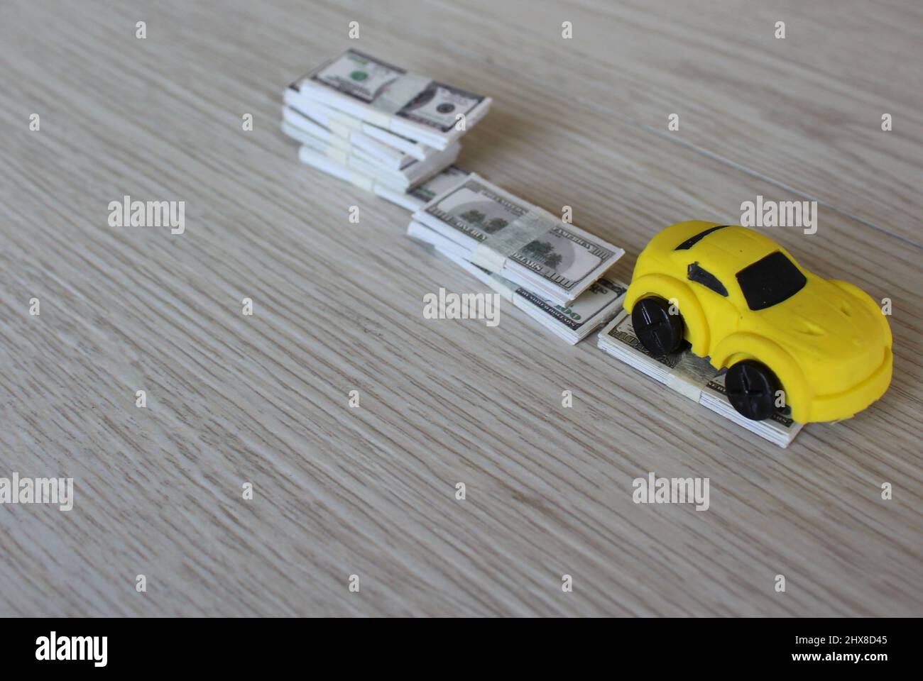 Selective focus image of toy car and stack of money. Car depreciation, value concept. Stock Photo