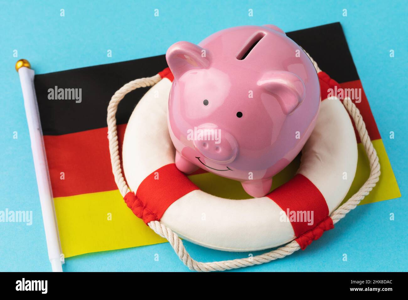 Piggy bank, lifebuoy and flag on a colored background, the concept of saving the German economy Stock Photo