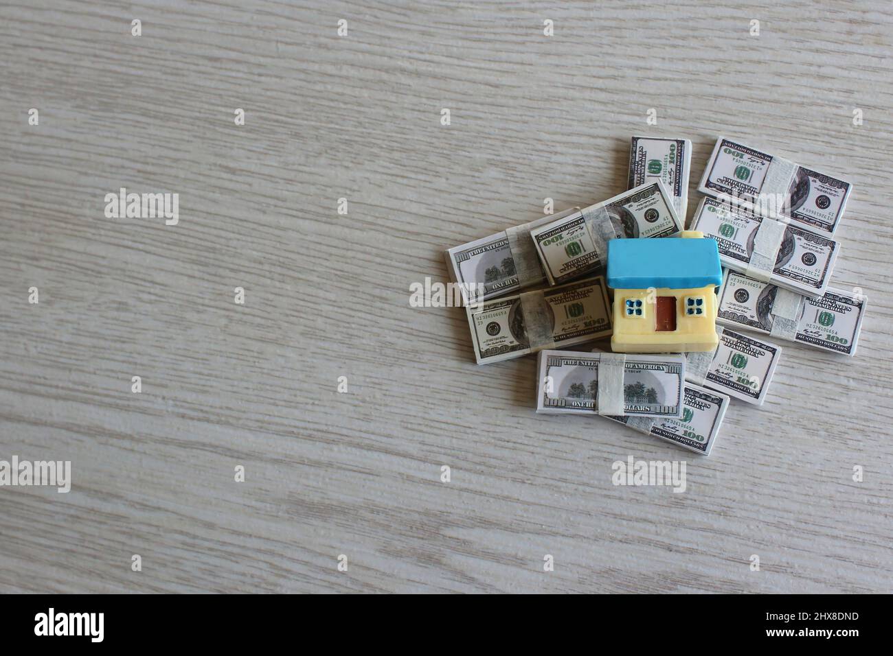 Property investment and house mortgage concept. Top view image of house on top of pile of money. Stock Photo