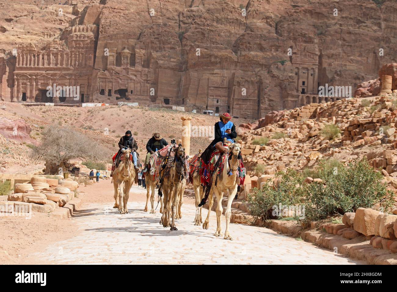 Bedouins riding their camels in the Colonnaded Street at Petra in