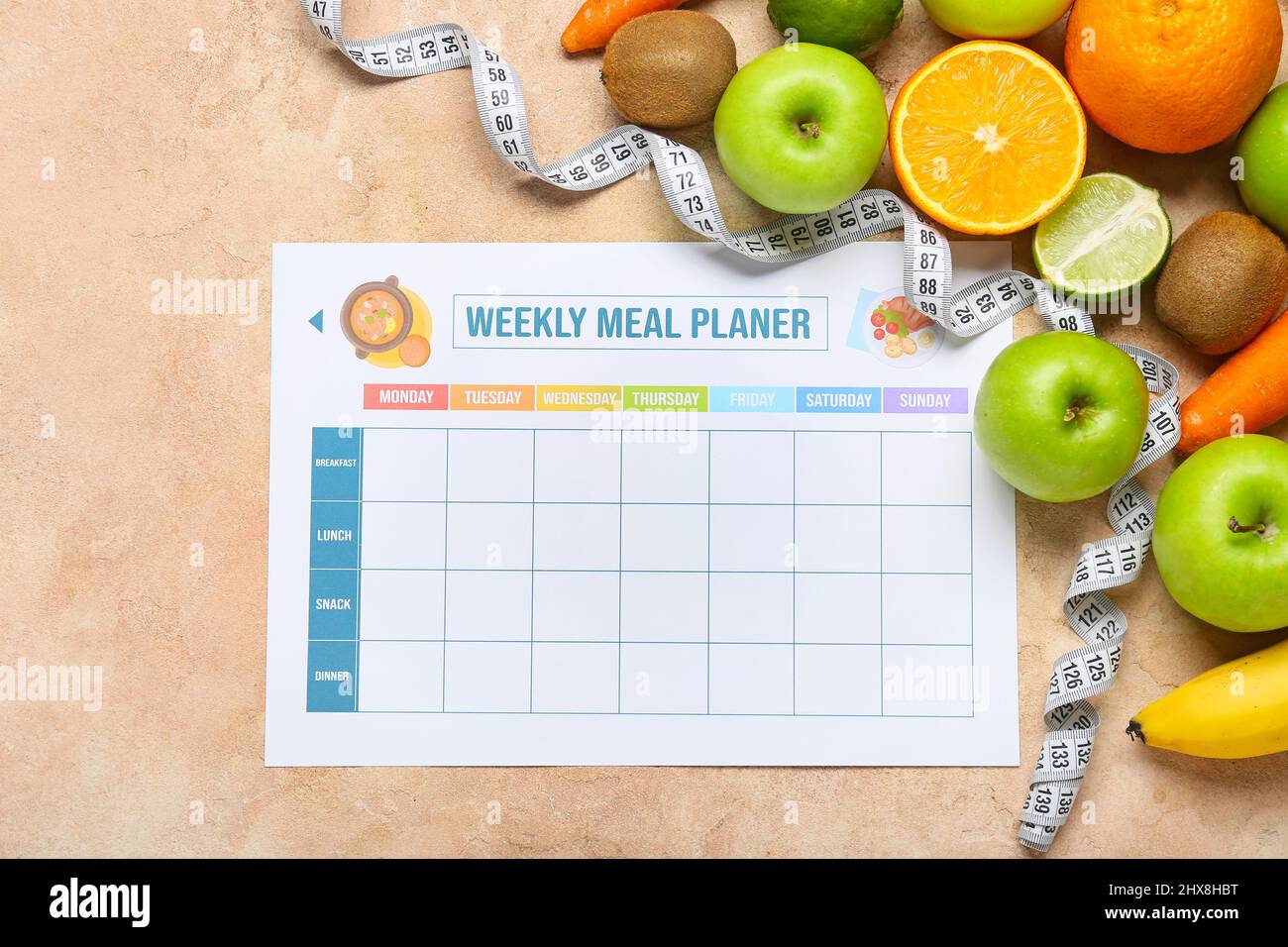 Weekly meal planner and different healthy products on beige background Stock Photo
