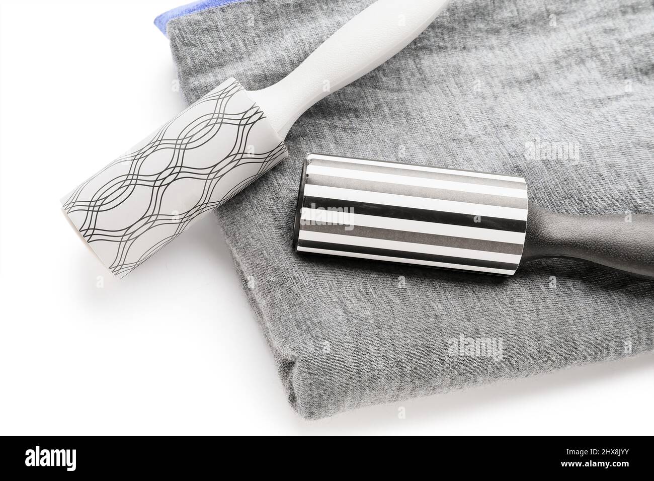 New lint rollers with clothes on white background Stock Photo