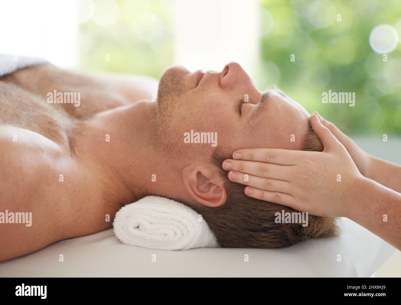 Letting your stress slip away.... Shot of a handsome man getting a head massage at a spa. Stock Photo