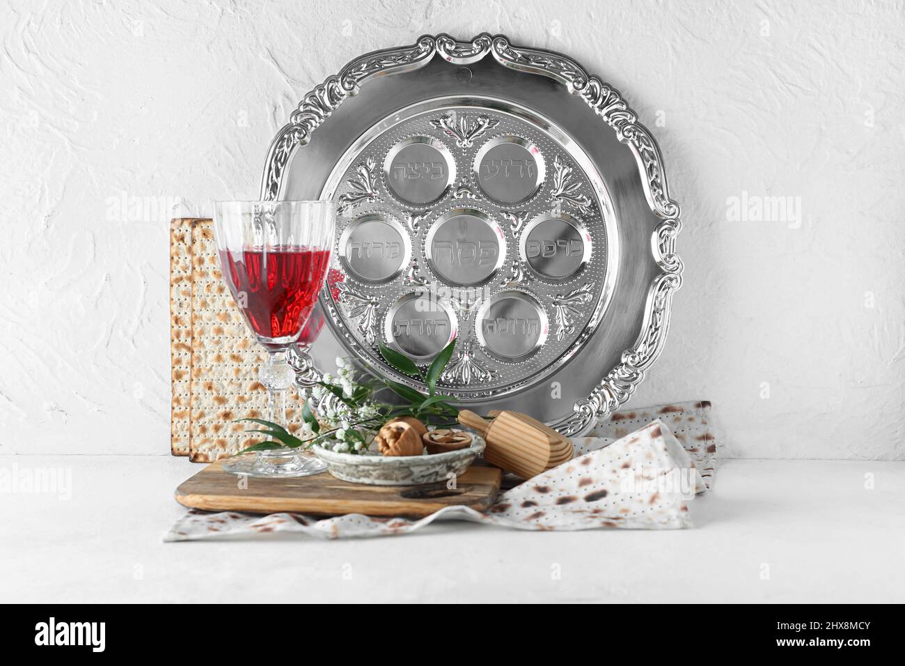 Passover Seder plate with glass of wine, walnuts and matza on white ...