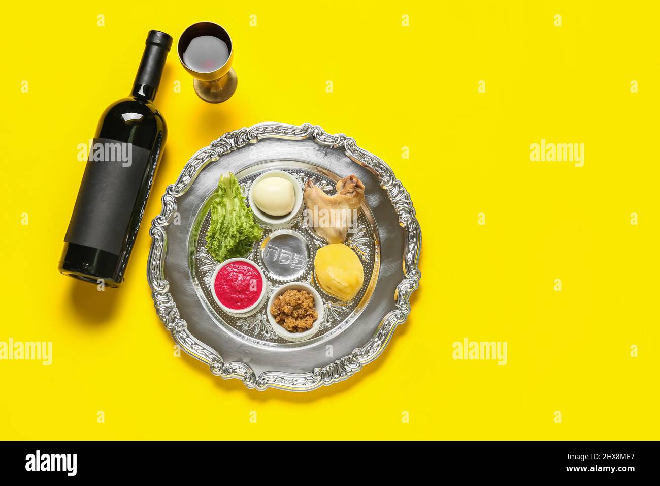 Passover Seder plate with traditional food and wine on color background ...