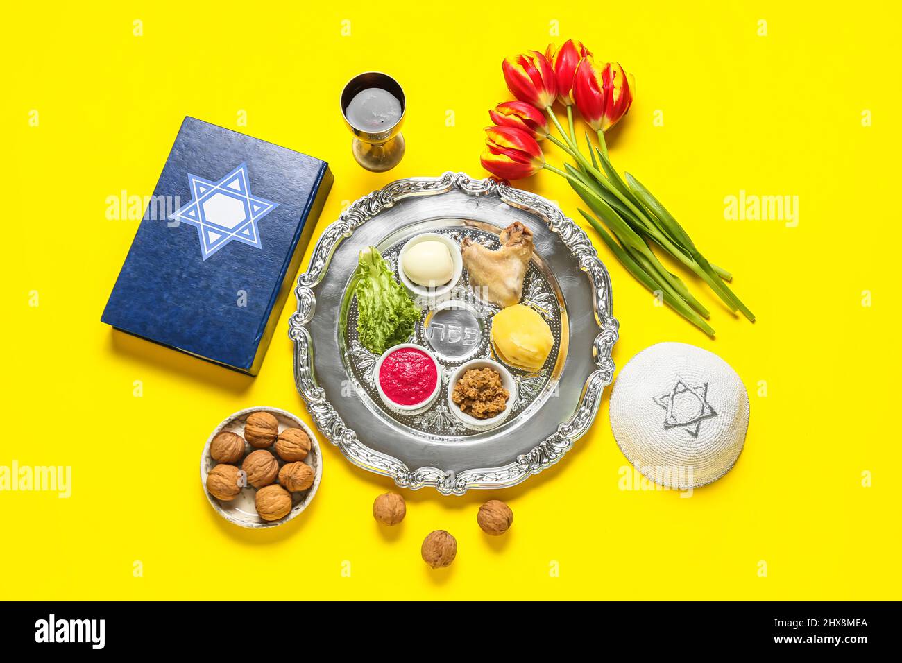 Passover Seder plate with traditional food, kippah and Torah on color ...
