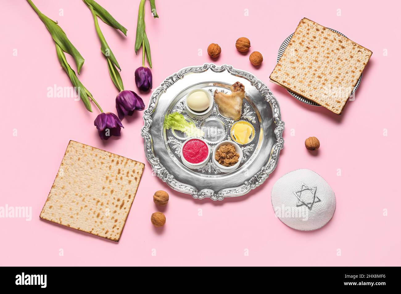 Passover Seder plate with traditional food and kippah on color ...