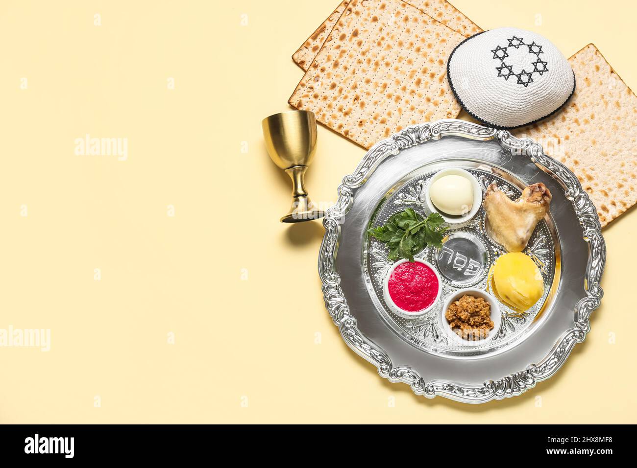 Passover Seder plate with traditional food and kippah on light ...