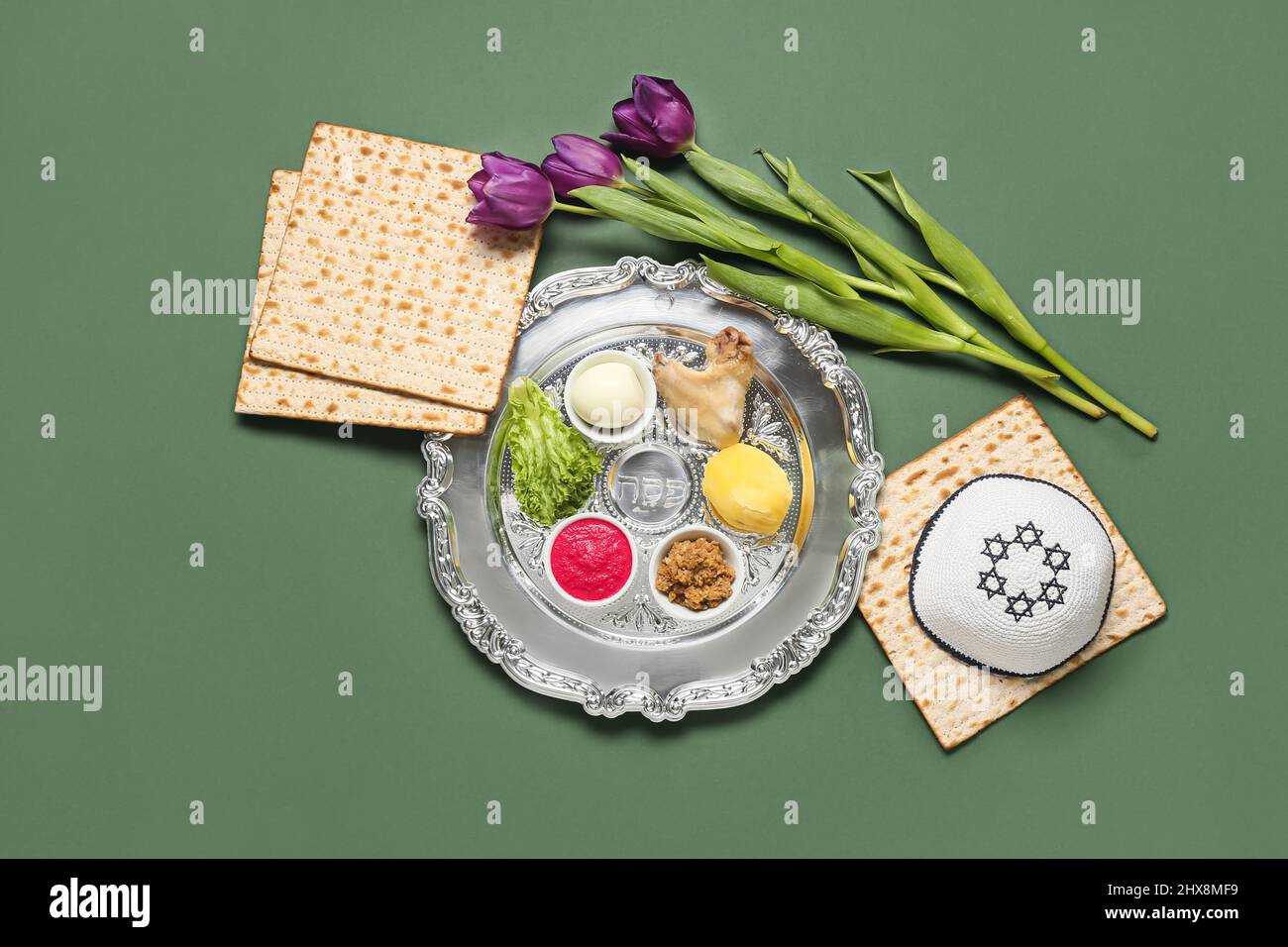 Passover Seder plate with traditional food and kippah on color ...