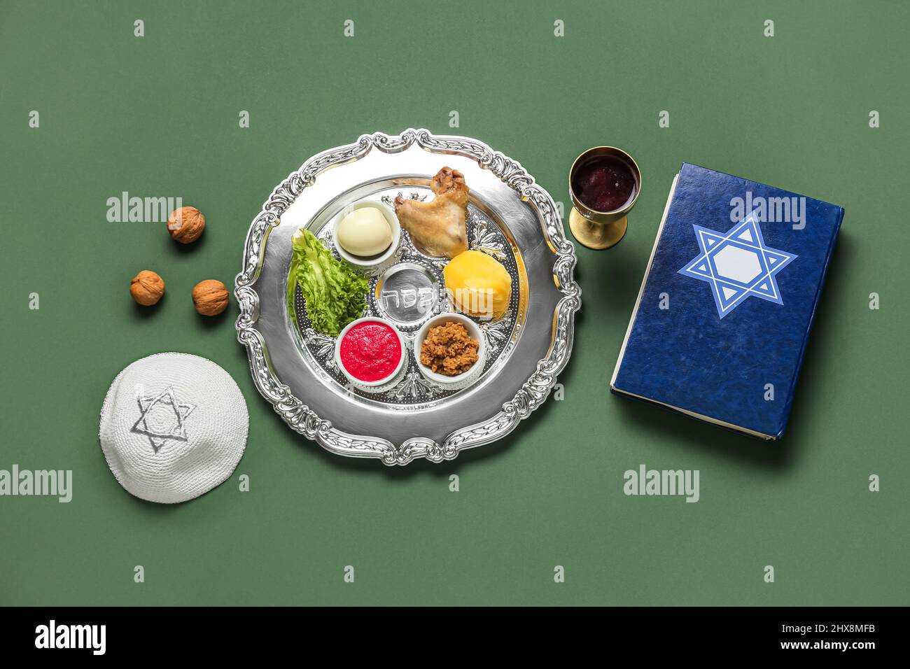 Passover Seder plate with traditional food, kippah and Torah on color ...