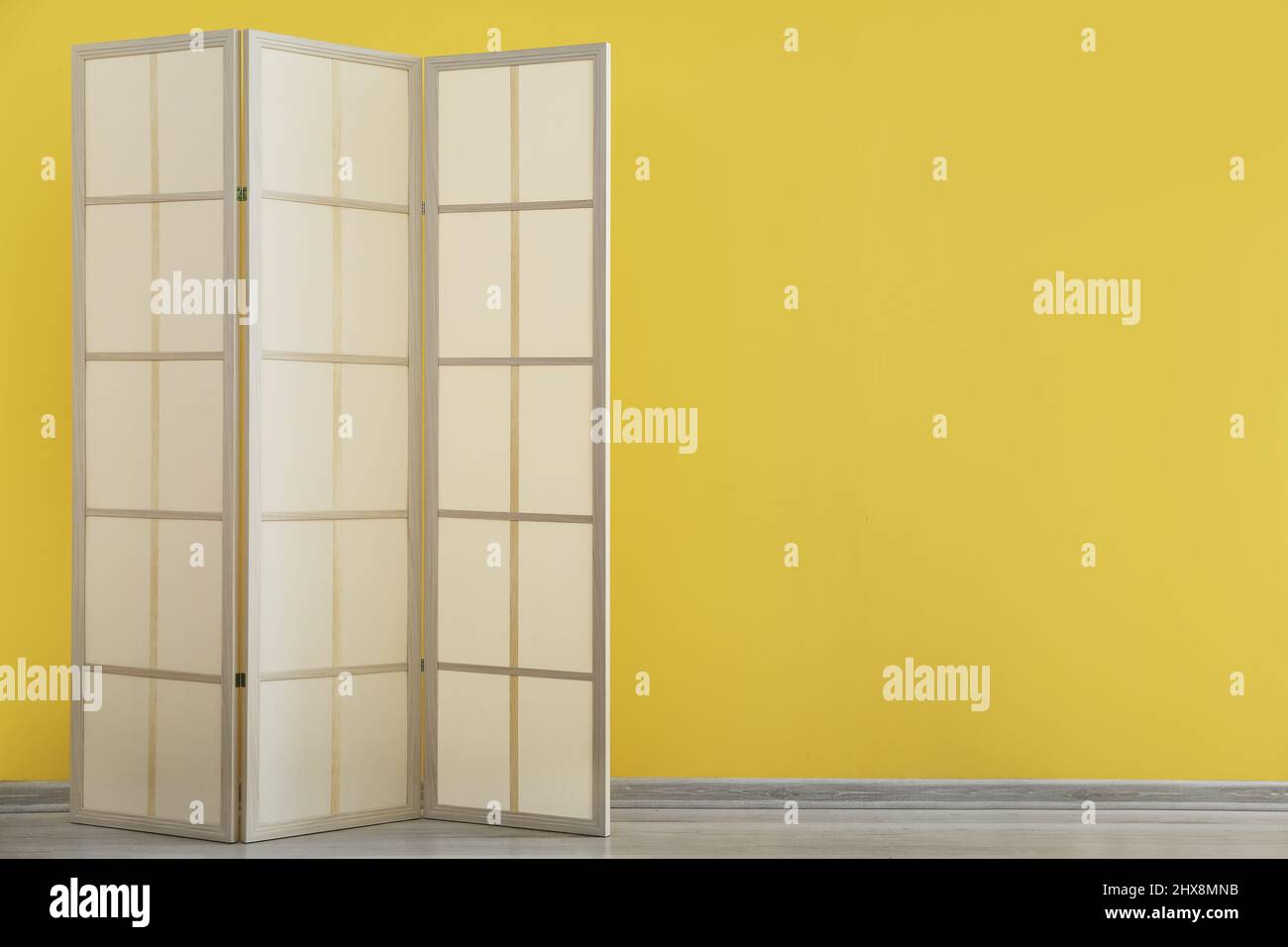 Stylish folding screen near color wall in room Stock Photo Alamy