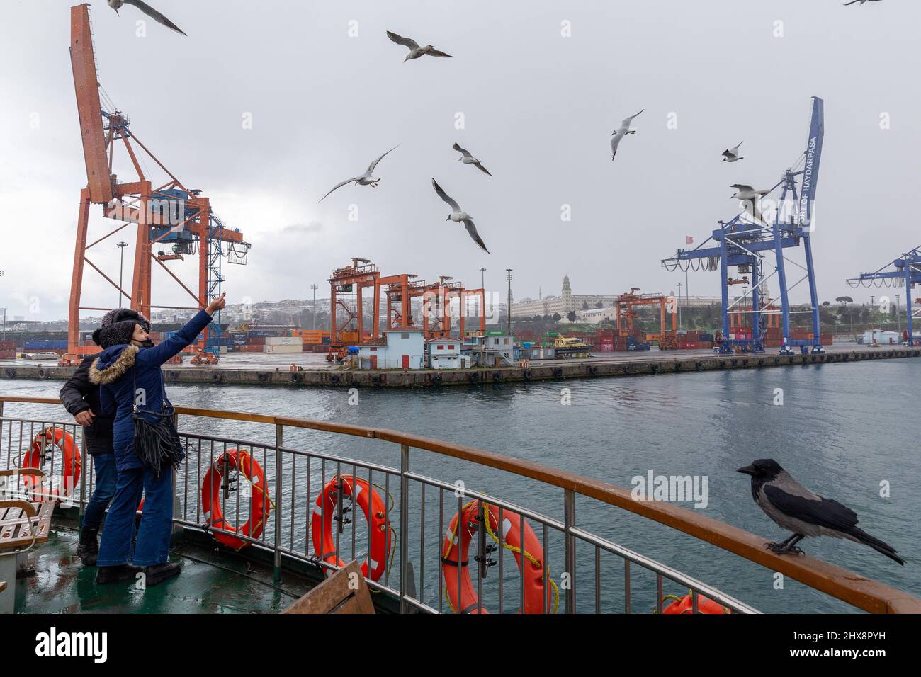 Istanbul, Turkey. 10th Mar, 2022. March 10, 2022: People feeding seagulls on the city lines ferry on a snowy day and Haydarpasa port in the background in Istanbul, Turkey on March 10, 2022. The snowfall, which started yesterday and continues intermittently, continues in Istanbul. After the warnings of the General Directorate of Meteorology, the snowfall, which started in the high parts of the city yesterday and continued in some regions throughout the night, increased its effect in the morning hours. Snowfall varied throughout the day. (Credit Image: © Tolga Ildun/ZUMA Press Wire) Credit: ZUMA Stock Photo