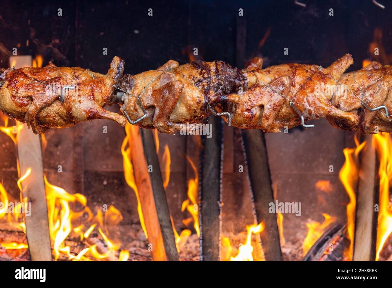 Roasting chicken on an open fire in the market Stock Photo Alamy