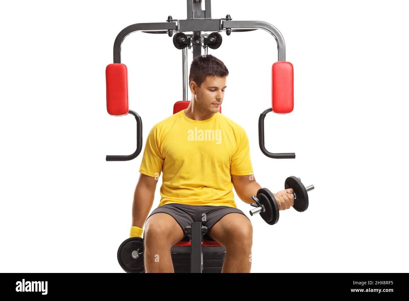 Young man exercising on a fitness machine isolated on white background Stock Photo