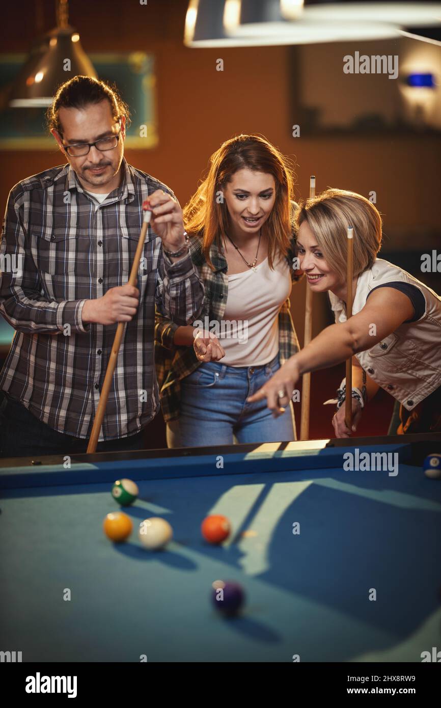 Billiards game. young friends playing pool together Stock Photo - Alamy