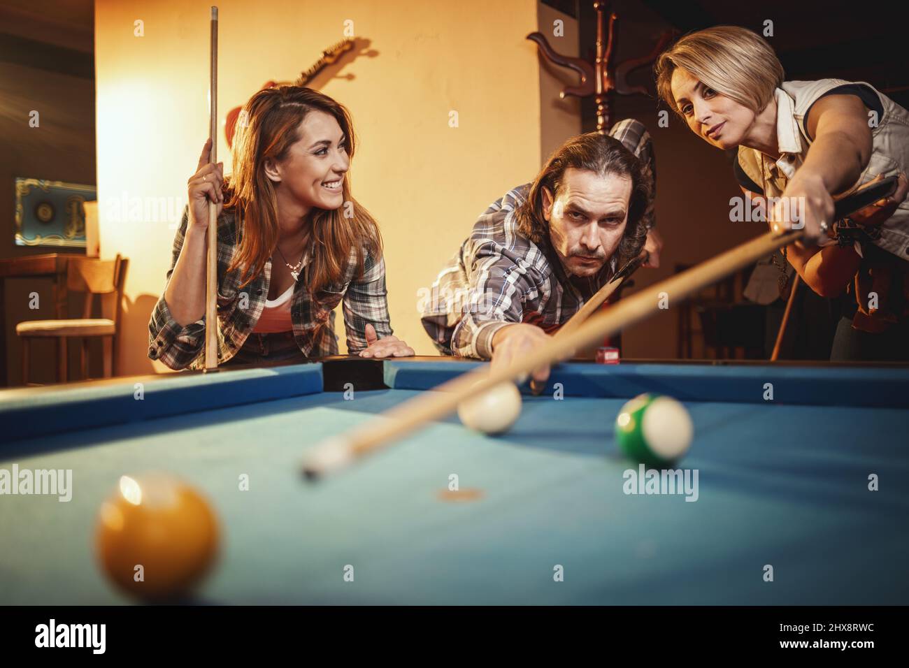 Billiards game. young friends playing pool together Stock Photo - Alamy