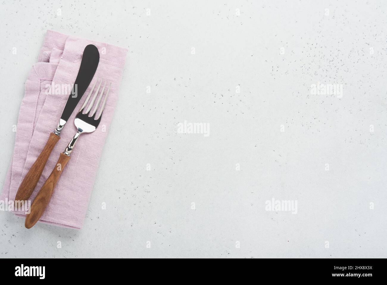 Vintage silverware. Rustic vintage set of wooden spoon and fork on light gray concrete background. Empty dishes. Top view. Mock up. Stock Photo