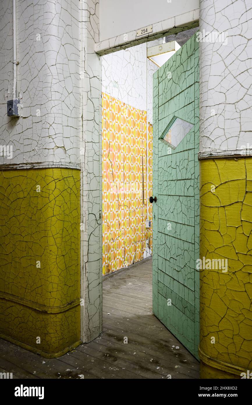 Cracked lead paint and retro wallpaper in an old abandoned building. Stock Photo