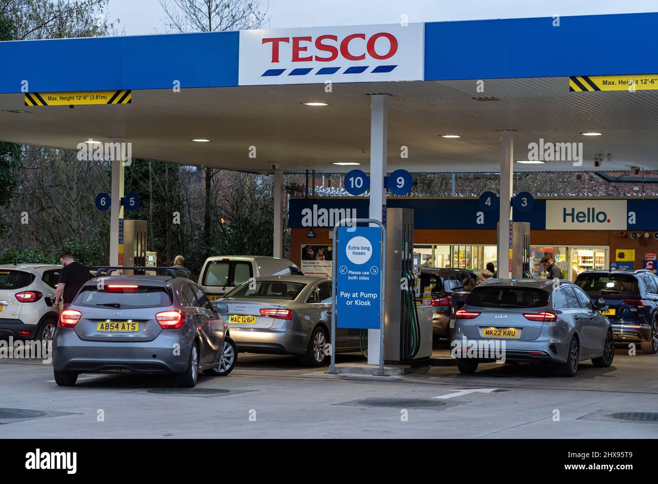 Wigan, UK: March 10, 2022: Queuing cars waiting to buy fuel at a Tesco petrol filling station as British drivers panic buy fuel Stock Photo