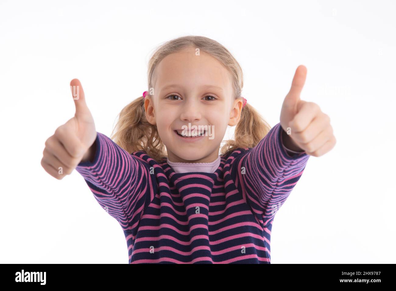 Successful young girl looking into camera for a thumbs up. Isolated studio shot with copy space. Stock Photo