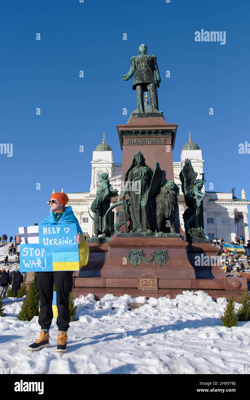 Helsinki, Finland - February 26, 2022: Demonstrator in a rally against Russia’s military aggression and occupation of Ukraine carrying Help Ukraine - Stock Photo
