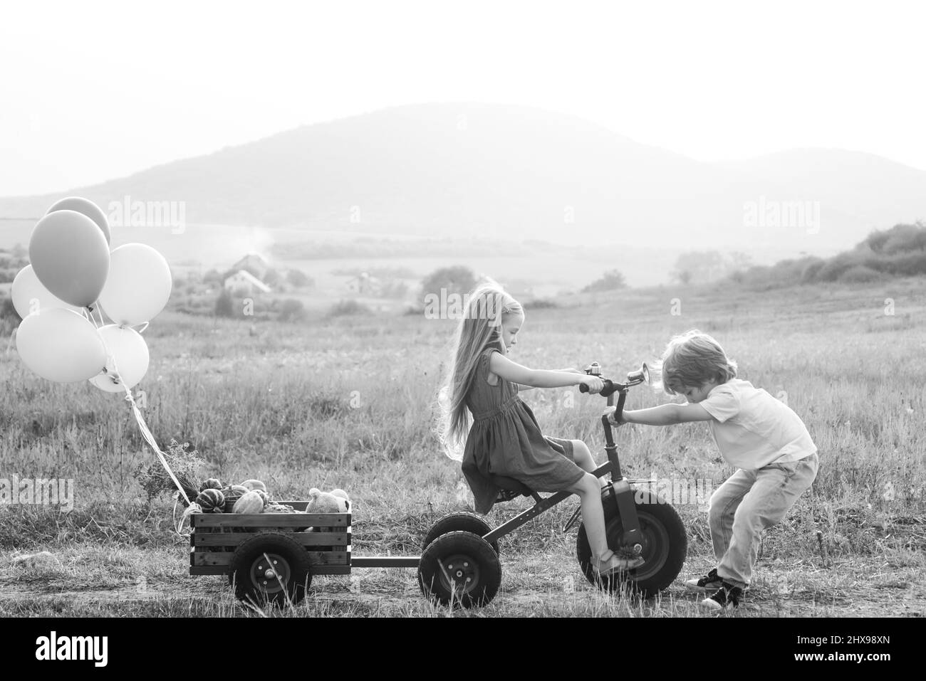 Kids play in autumn park. Happy Kid on summer field. Valentines day. Kids having fun in field against sky background. The concept of child friendship Stock Photo