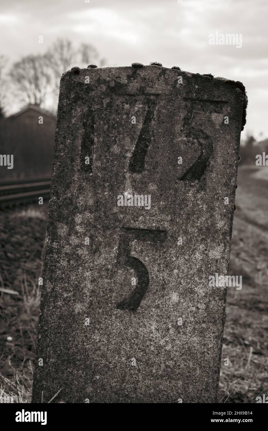 A sign made of solid stone. Drawn by the weather it stands on a ...