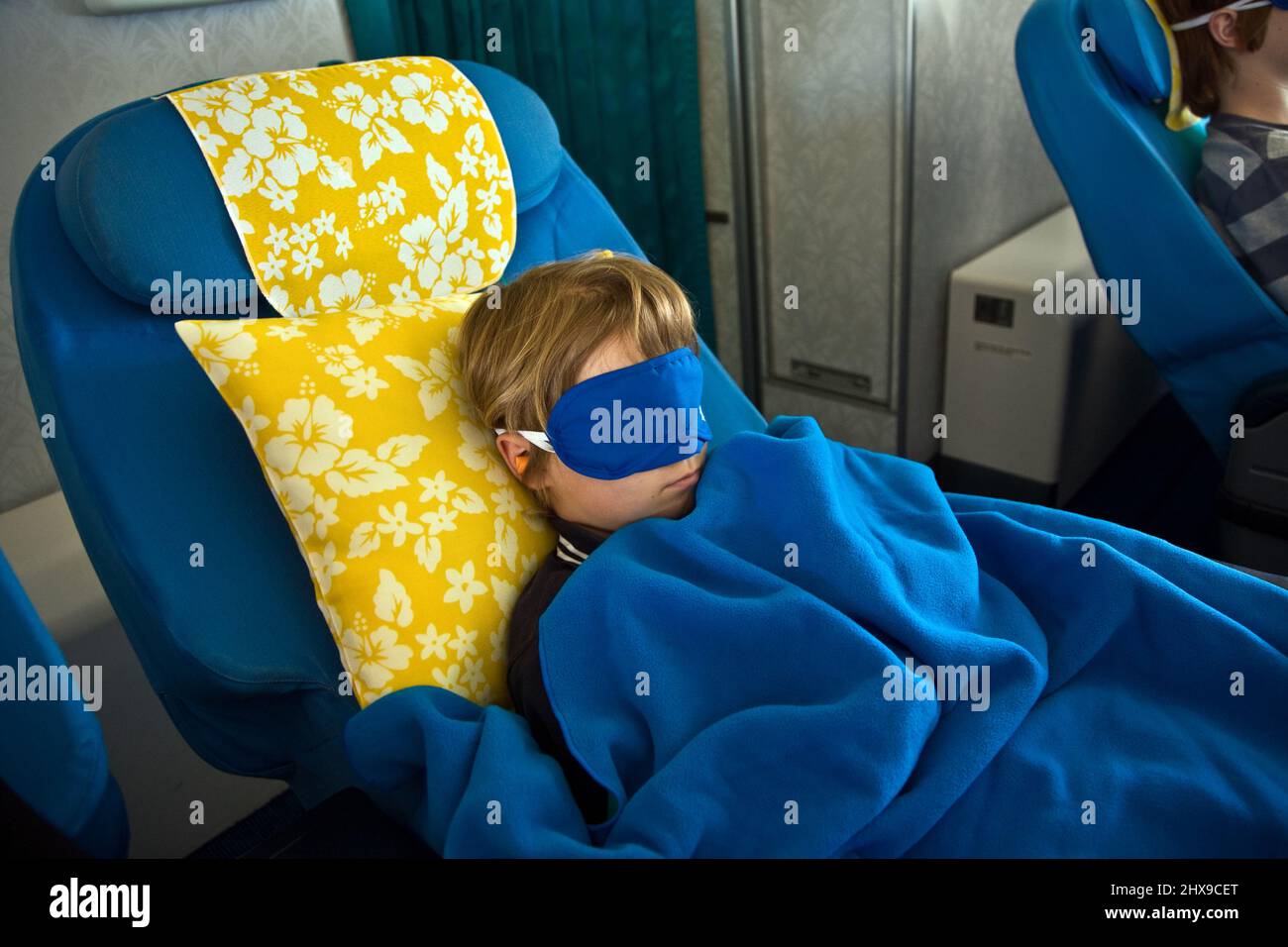 young passenger sleeping in the business class Stock Photo