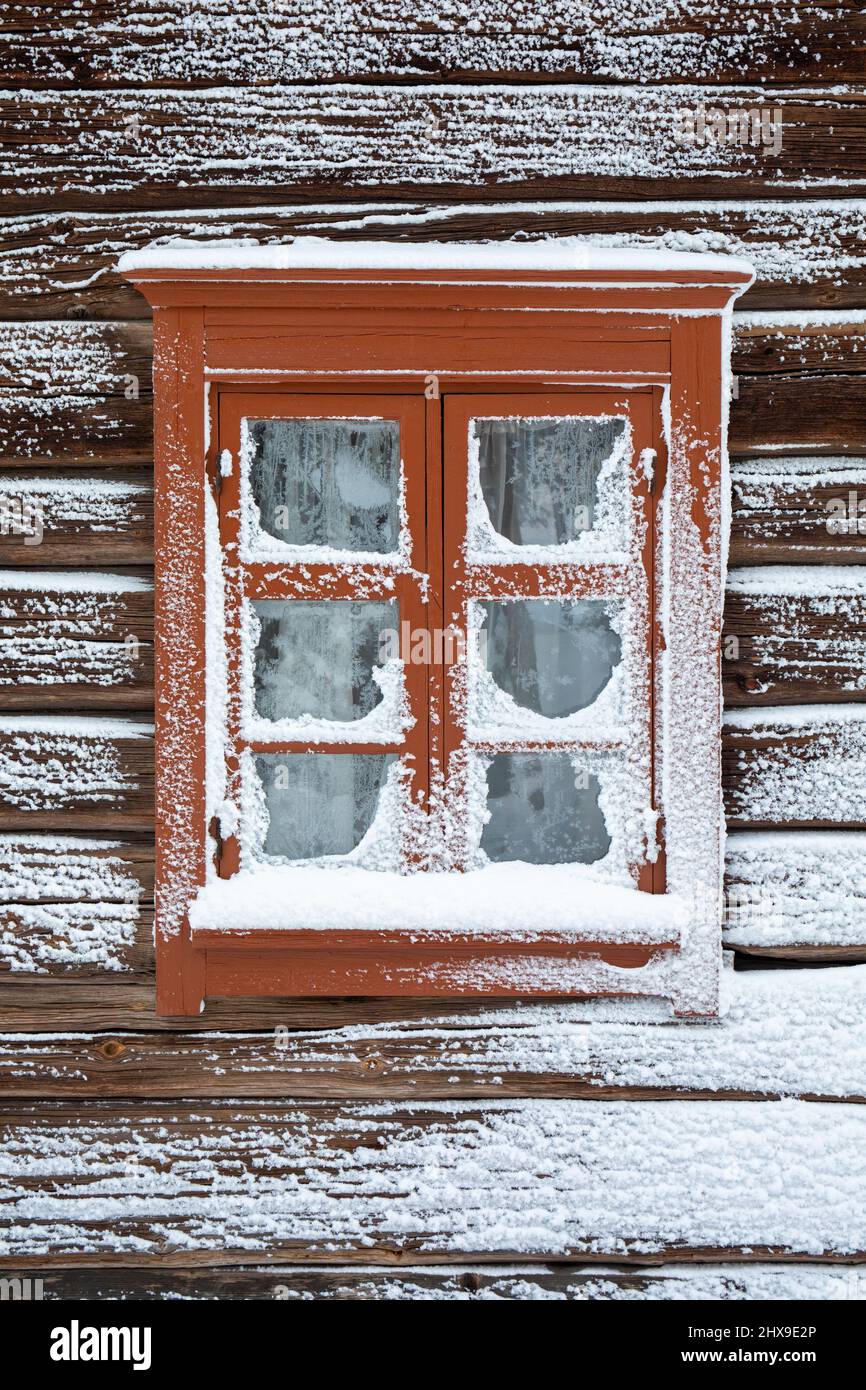 Old log building window with snow and hoarfrost in Seurasaari Open-Air Museum, Helsinki, Finland Stock Photo