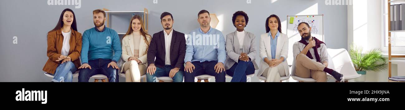 Diverse team of happy business people or company workers sitting in row in their office Stock Photo