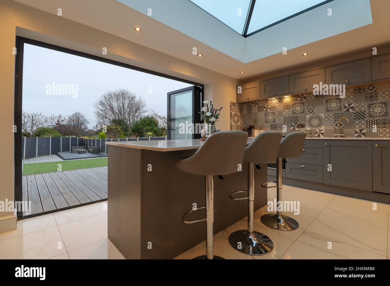 Ultra modern high end grey kitchen with lantern skylight and bi-fold doors Stock Photo