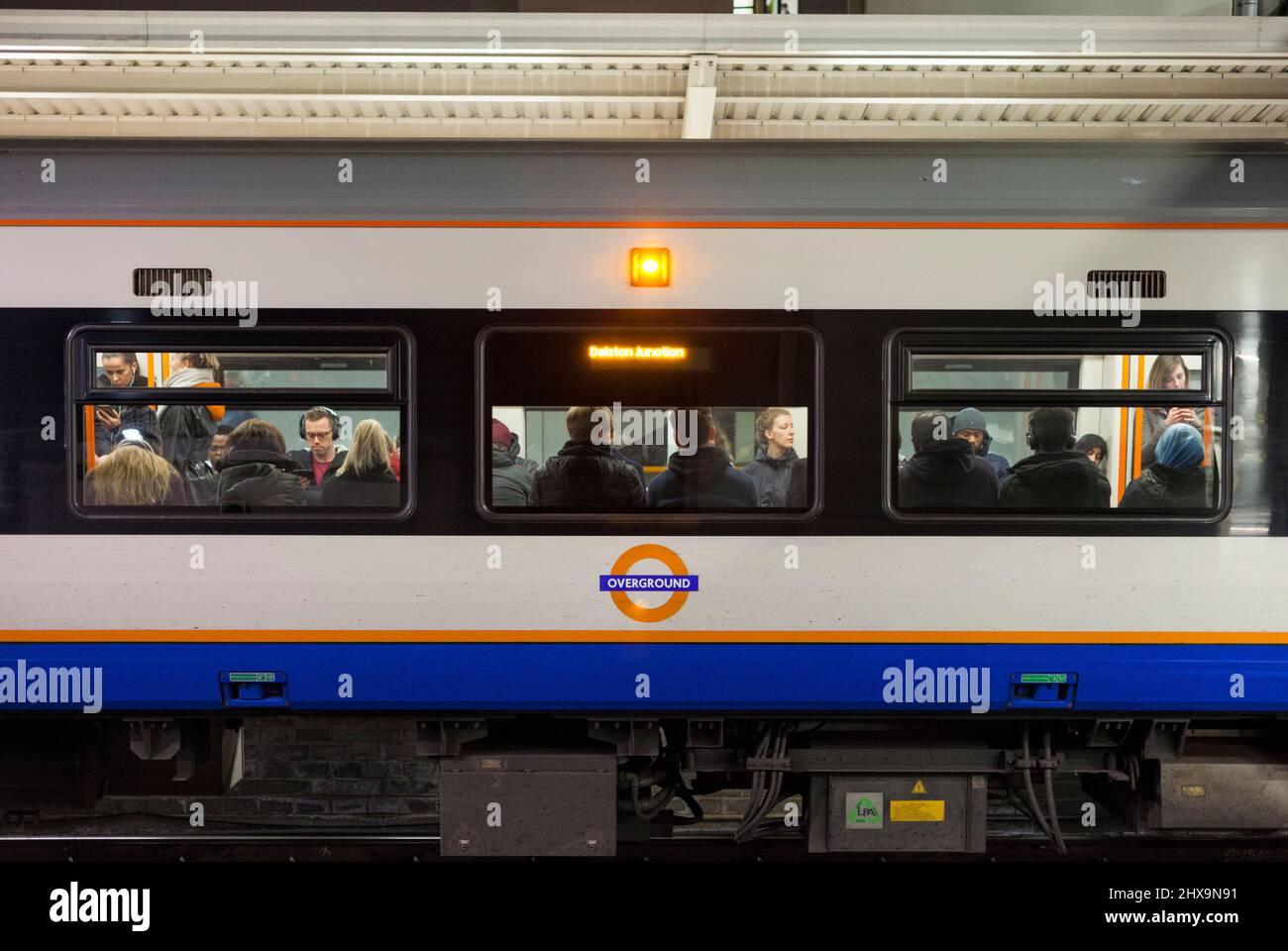 Passengers on a filled London Overground class 378 train showing the overground logo Stock Photo