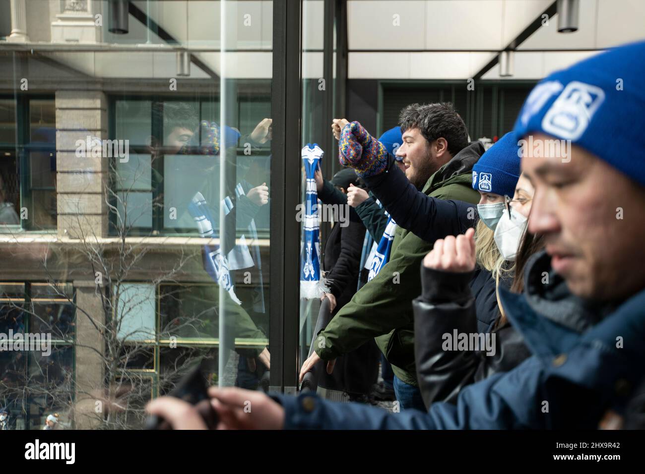 Minneapolis, Minnesota, USA. March 10, 2022, Protesters stand in the skyway of the IDS Center to cheer on the crowd of protesters below during a teachers union strike. Credit: Chris Juhn/Alamy Live News Stock Photo