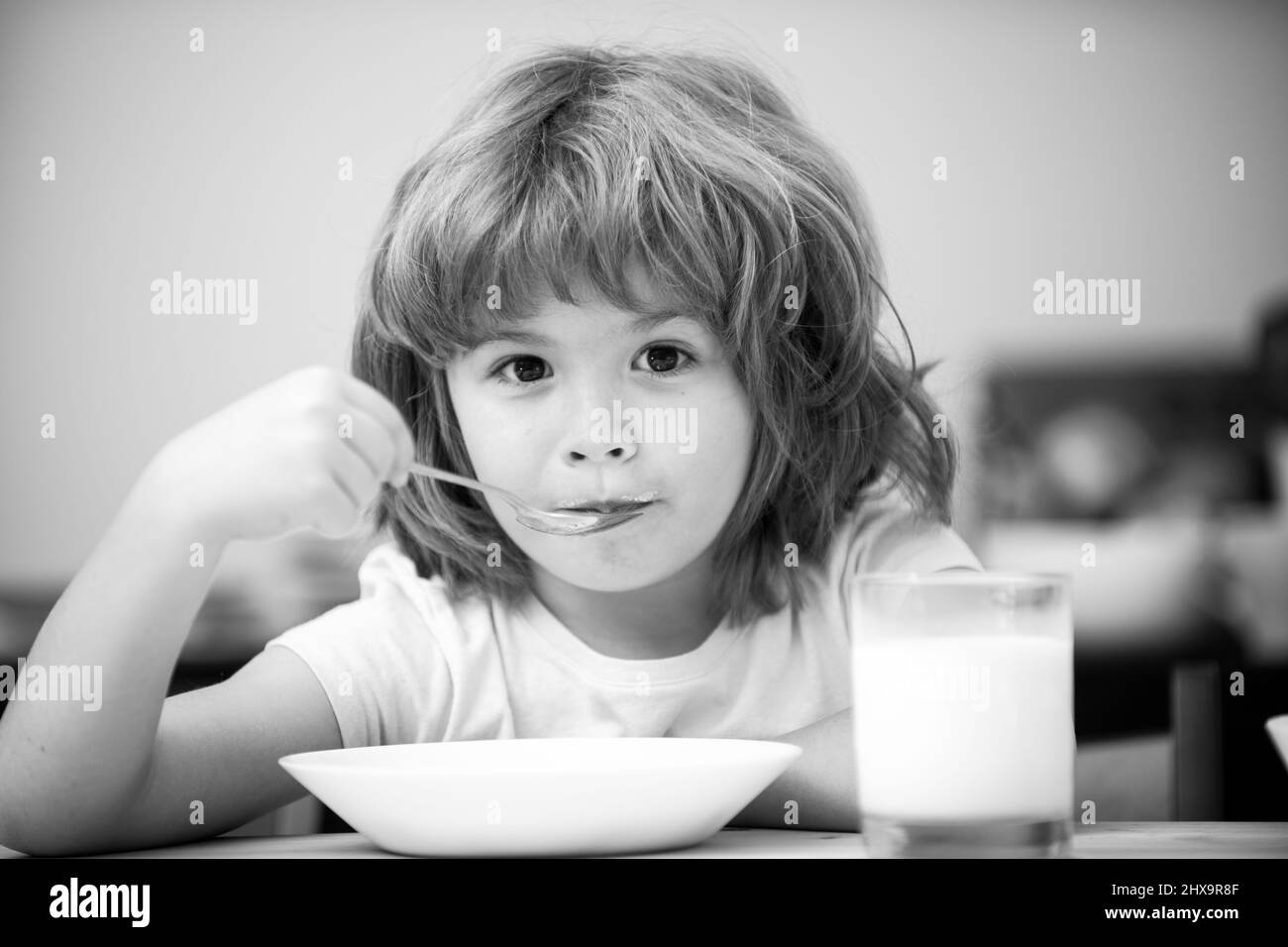 Closeup face of kid eating organic food, yogurt, milk. Child healthy