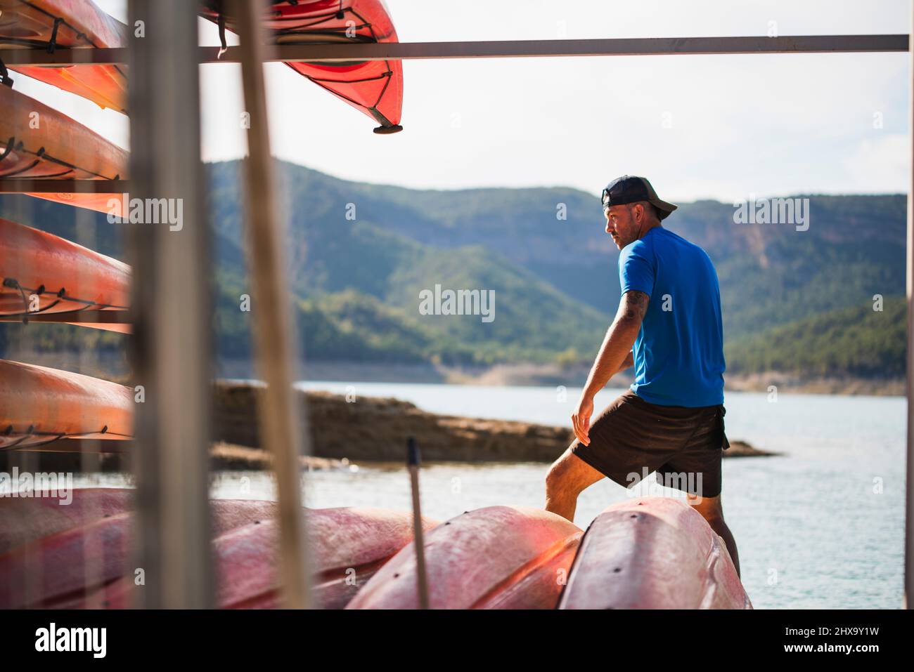 Young man doing maintenance work at a kayak rental company. Stock Photo