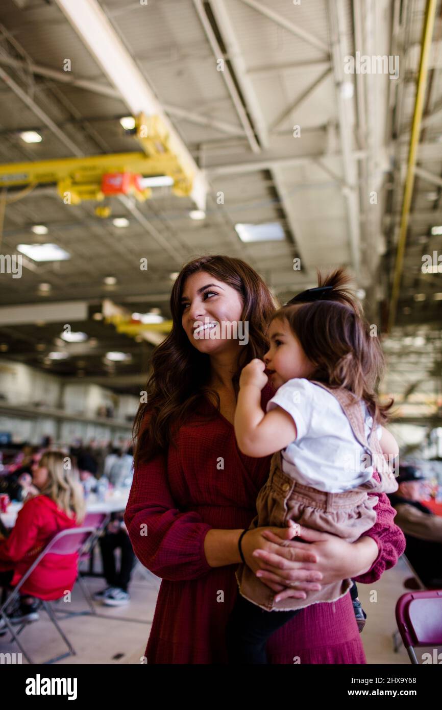 Mom Holding Daughter for Military in San Diego Stock Photo