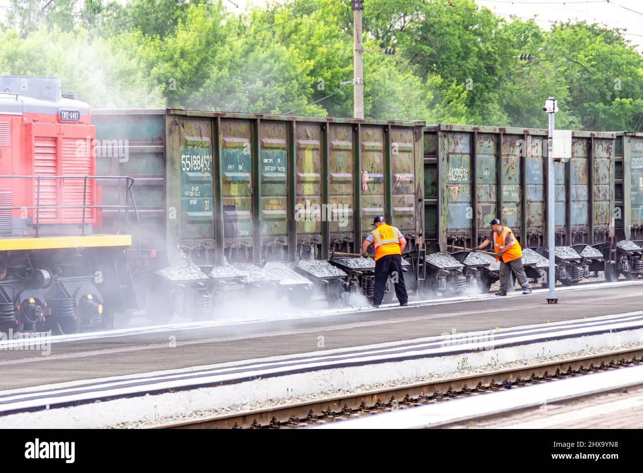 Kemerovo, Russia, 03 June 2021.Maintenance personnel of railway station carry out current repairs of track ballast of railway track by pouring large g Stock Photo