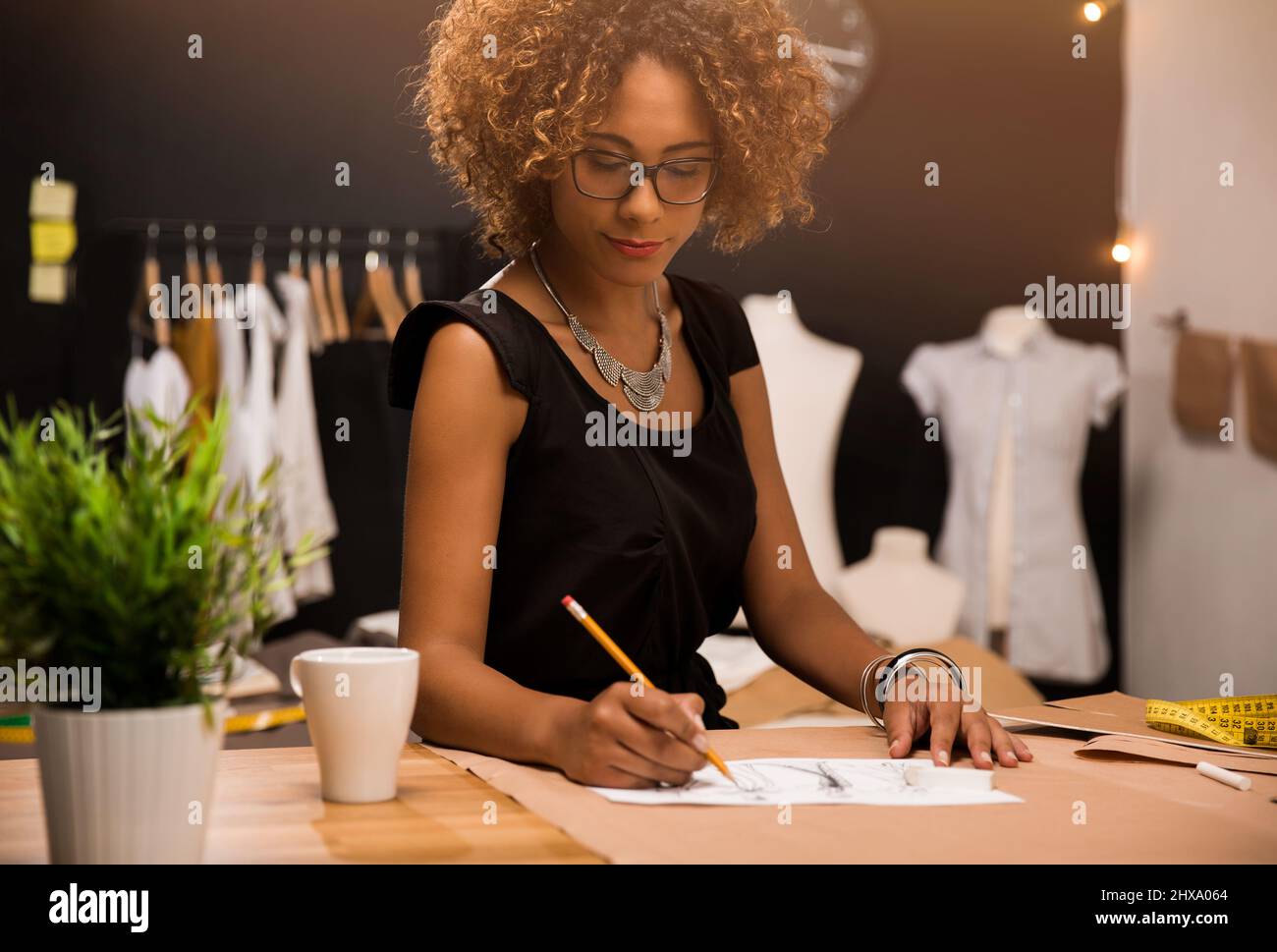 Fashion designer working on her atelier Stock Photo - Alamy