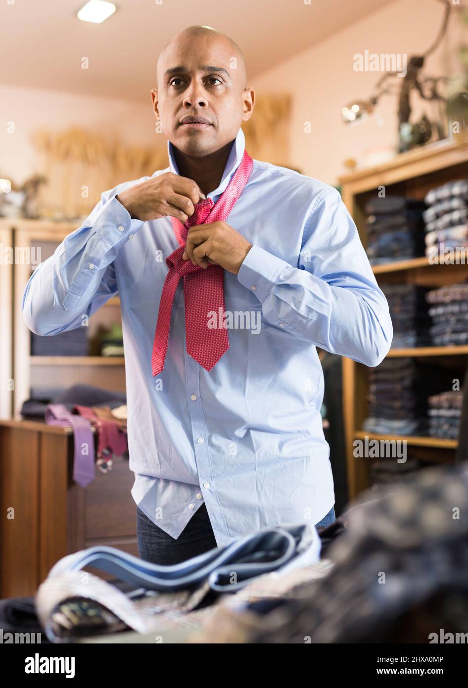Man choosing new tie in clothing boutique Stock Photo - Alamy