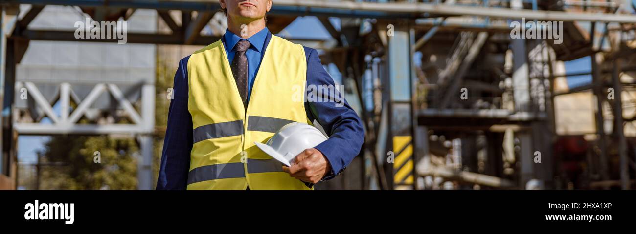 Male engineer standing outdoors at production plant Stock Photo