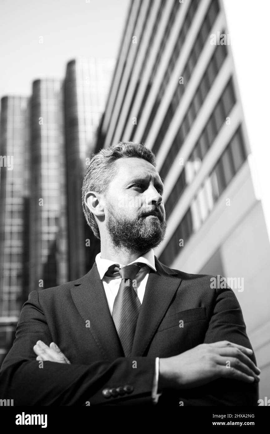 Portrait of businessman standing in a office. Entrepreneur, business portrait. Businessman standing proud with arms crossed outside. Stock Photo