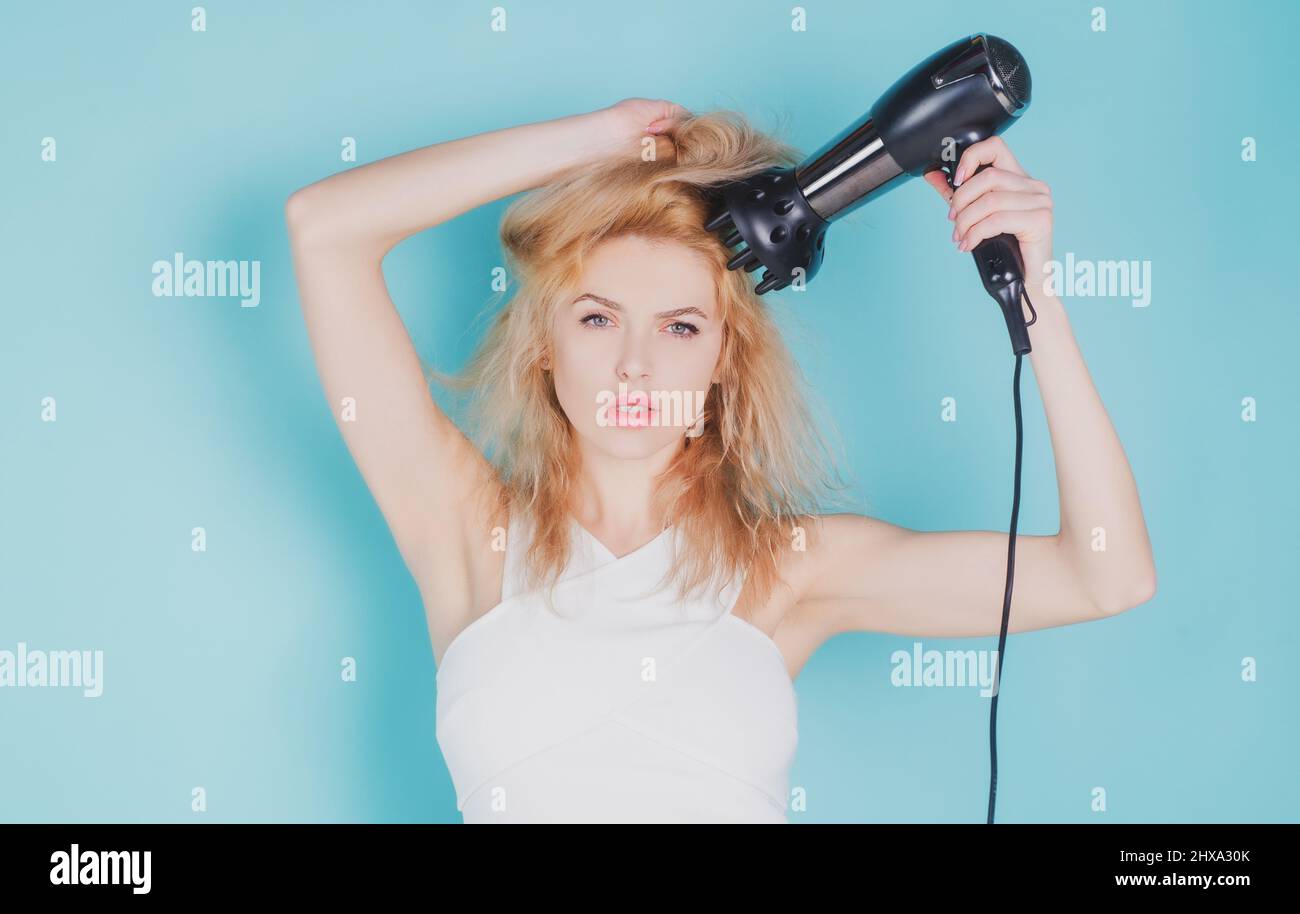 Woman using hair dryer. Young girl with drying hair with hair dry Stock