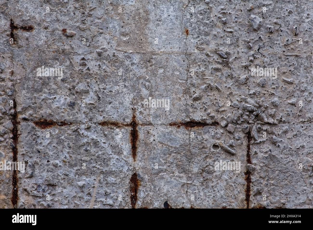 Macro fragment of an old gray concrete wall with rusty rebar. Material aged, construction. Brutal background. Stock Photo